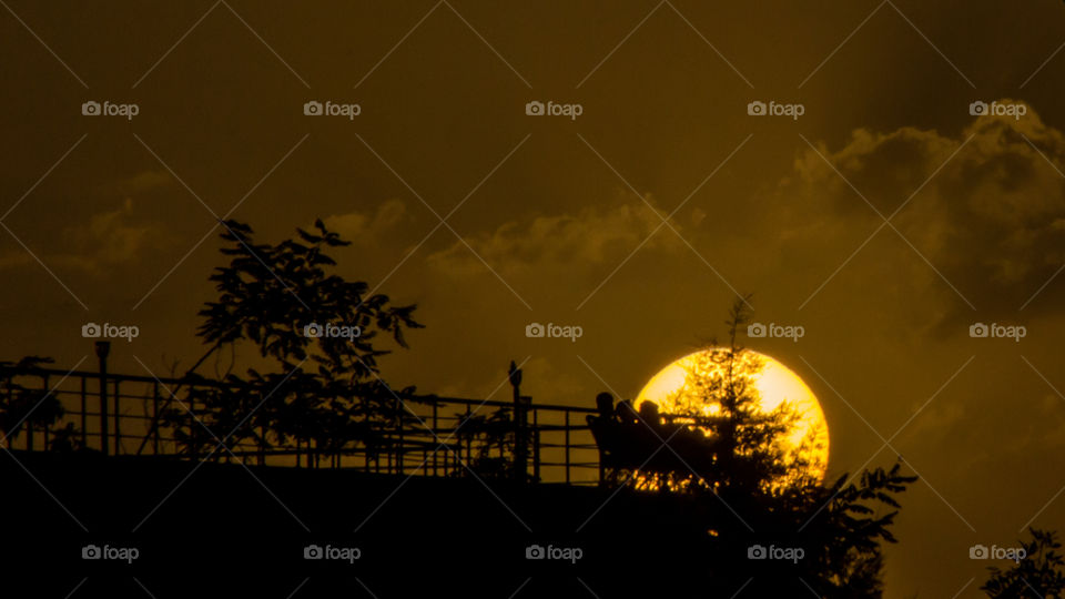 Sunset and young people sitting dark 