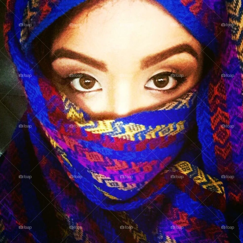 Close-up of a woman with scarf covering face