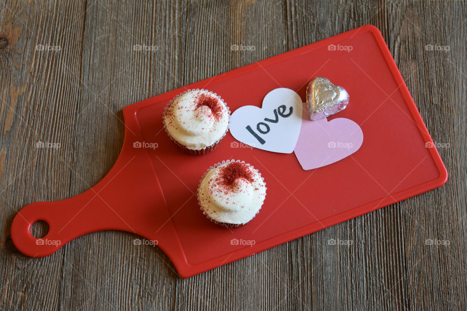 Red velvet cupcakes with Valentine's day sentiments on wood background