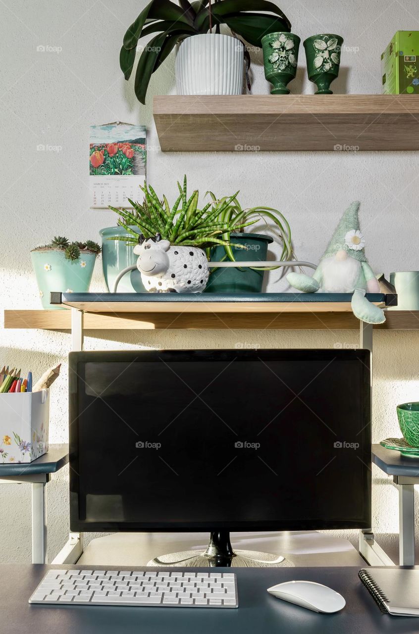 A desk with a springtime feel, with plants and greenery