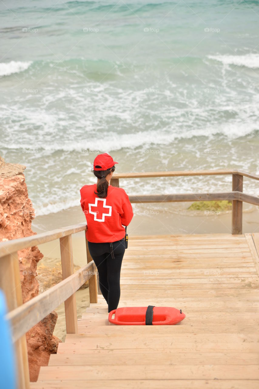 Rear view of women standing near beach