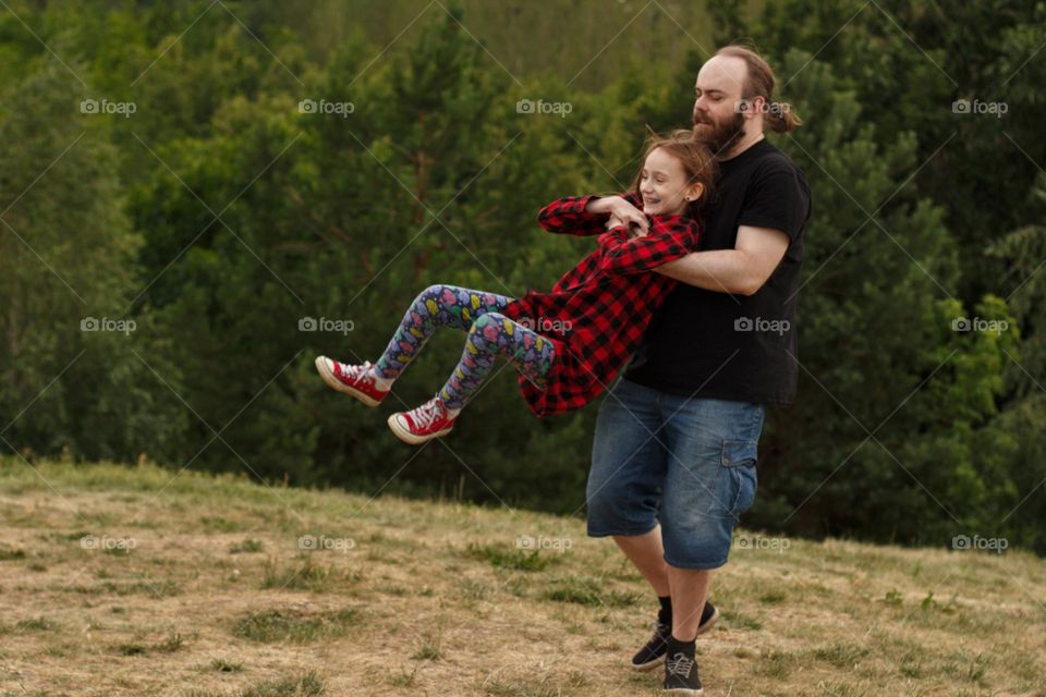 Dad spins his daughter on the field