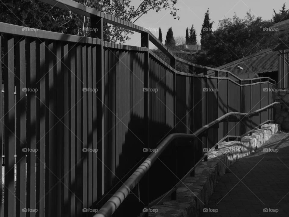 Black and white picture with a fence on stones