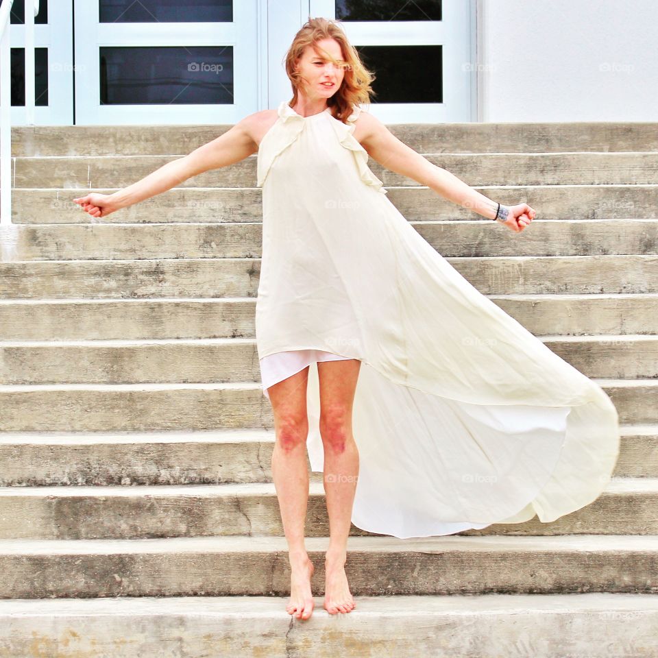 Dancing and fluttering in the breeze in front of an urban geometric architectural building.