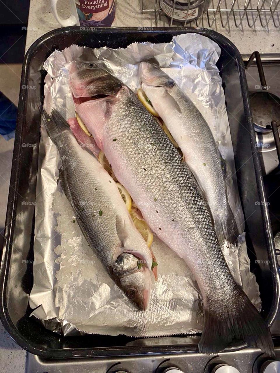 Raw fish in a tray with foil prepared for baking