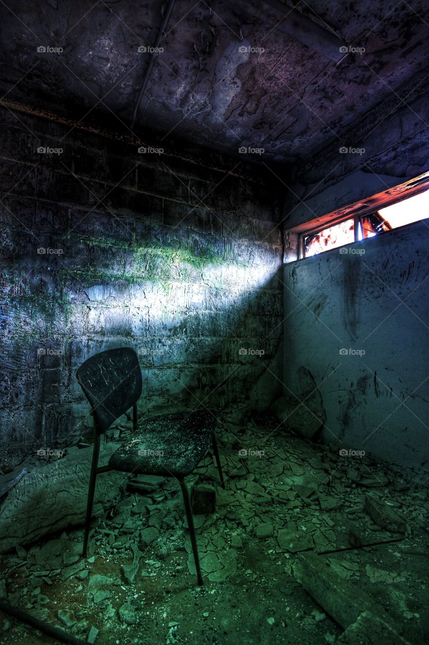 A single window sheds light onto an abandoned room.
