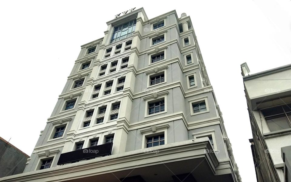 Photo of a white hotel with a classic design on a cloudy background