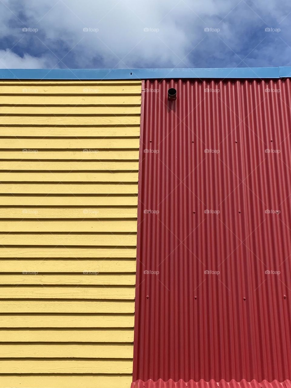 Red and yellow building against a blue sky.