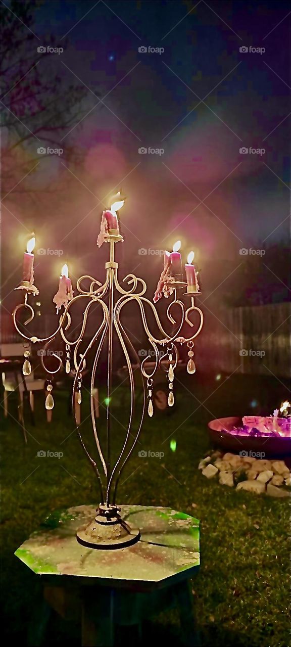 On the other side of the globe five white candles on a handcrafted candelabra burn in celebration of “New Year’s Eve 2023” along with various bonfires in a garden somewhere in Bavaria right before the fireworks start. Hypnotic Productions