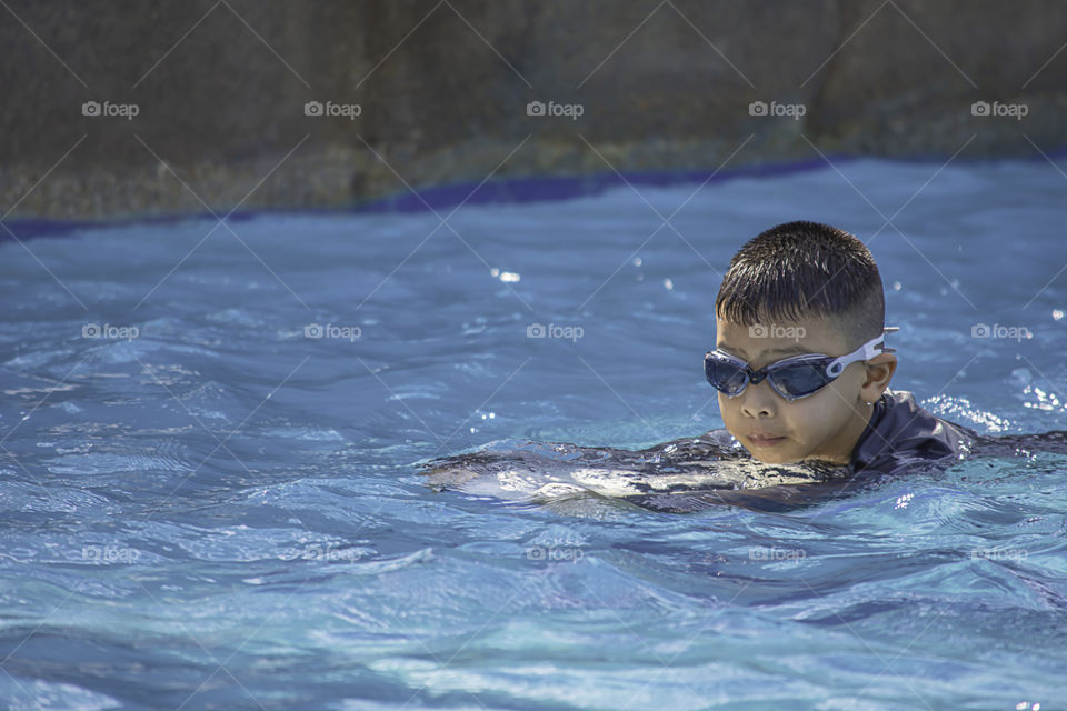 Asean boys are swimming in the pool.