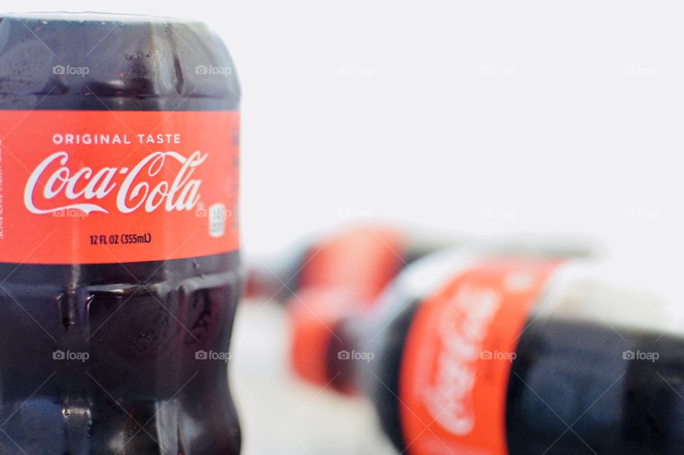Three plastic bottles of Coca-Cola on a white background