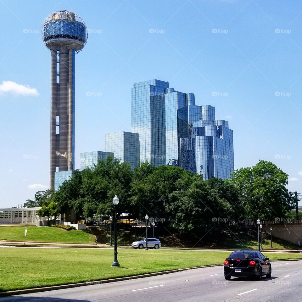 Reunion tower beside the Hyatt Regency against blue skies on a sunny summer day in Dallas