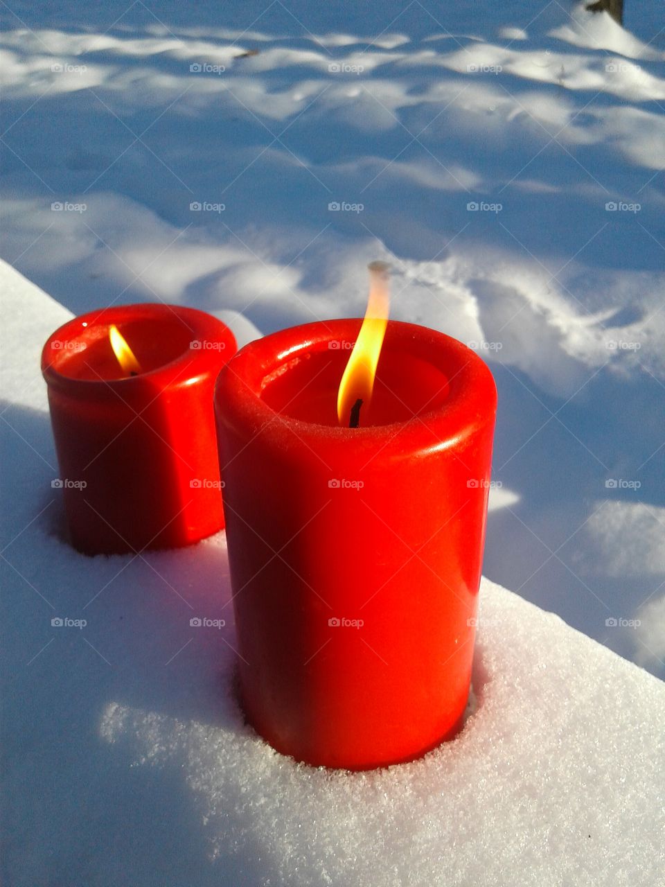 Glowing candles in snow