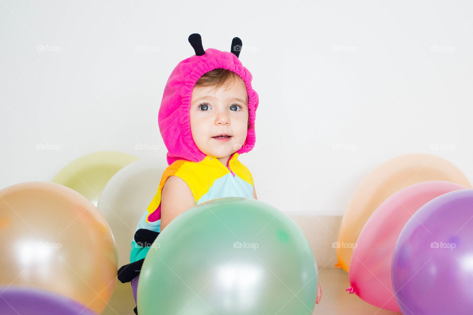 Close-up of baby with multicolored balloons