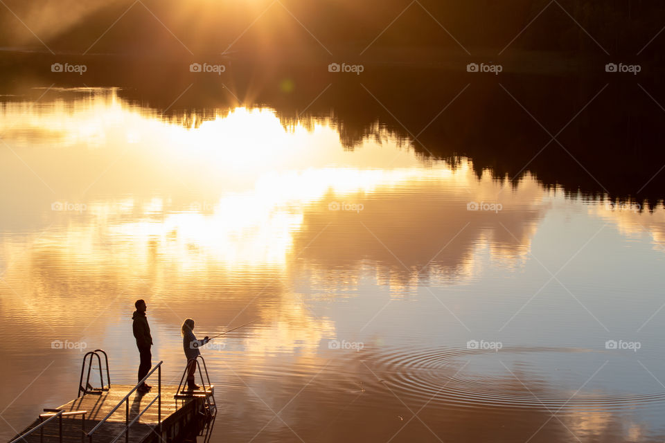 Fishing from a pier at sunset, golden hour , fiskar från brygga i solnedgång 