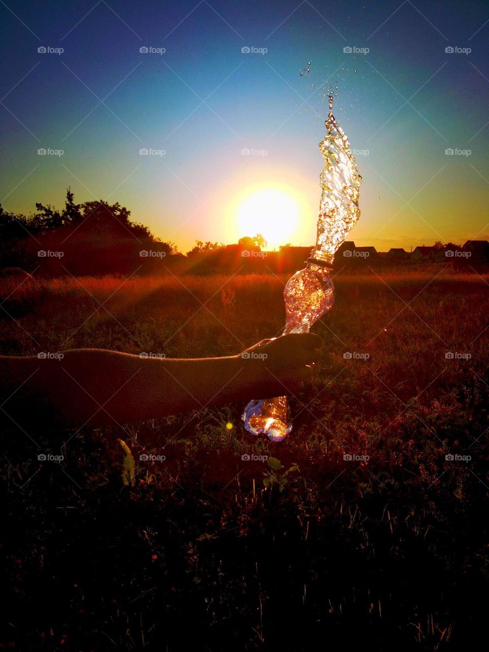 Water bottle on sunset background
