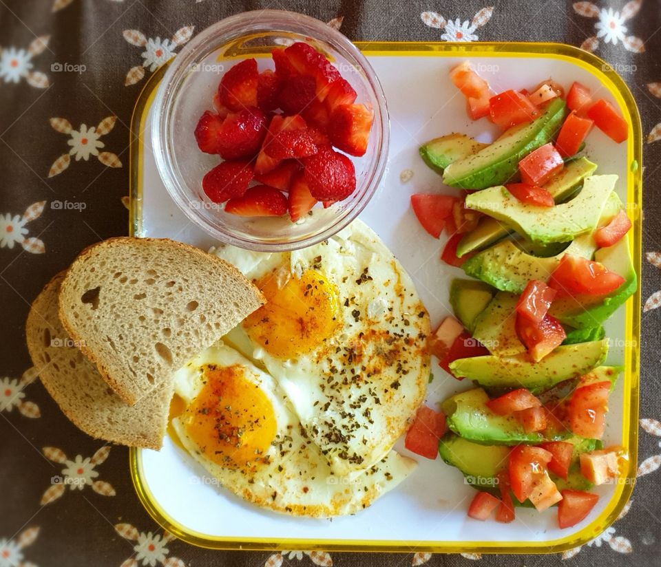 Eggs, bread, avocados, tomatoes, and strawberries.