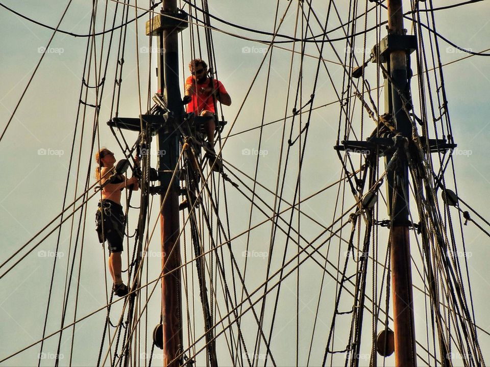 Sailors climb rigging of tall ship