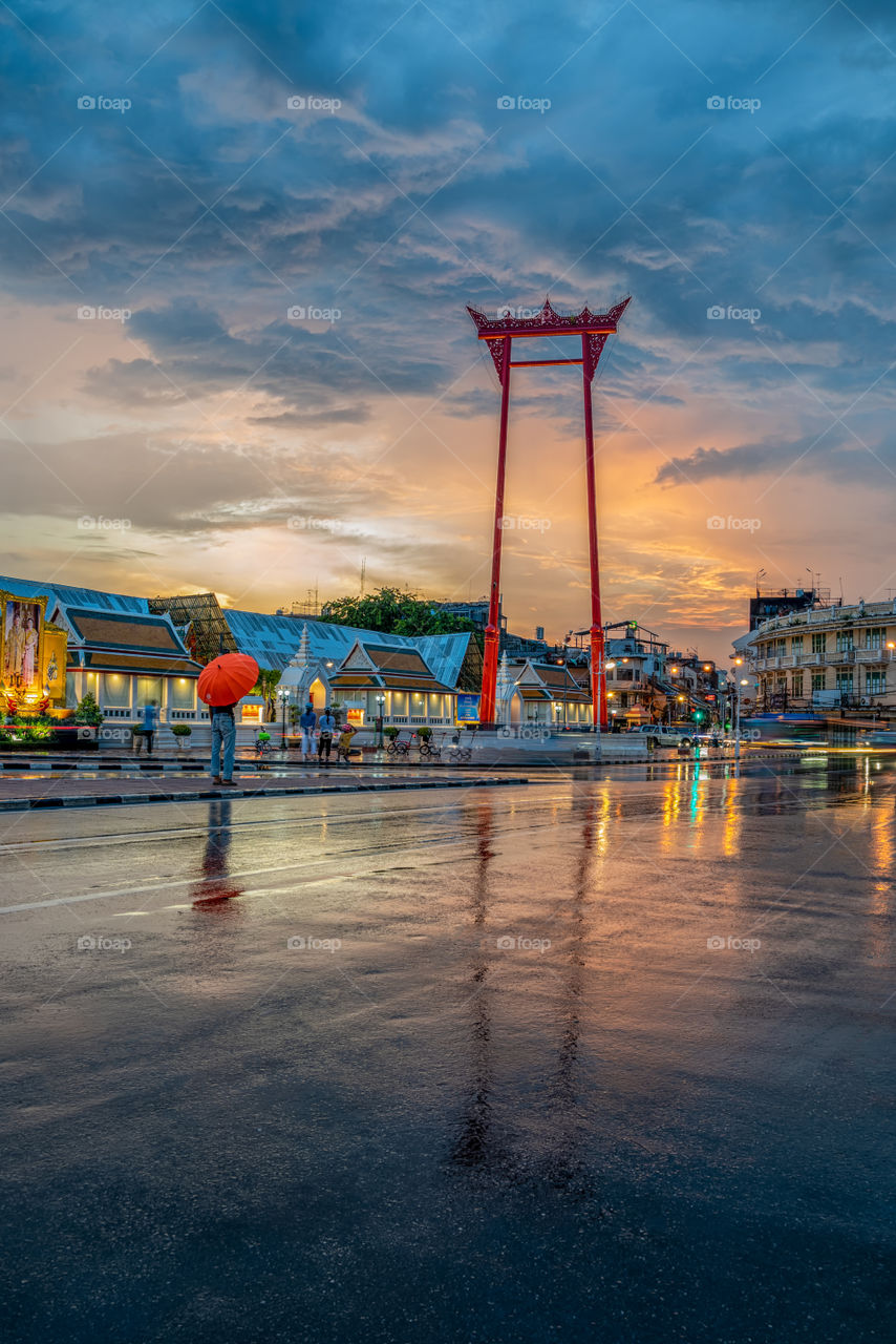 Big swing column landmark in Bankgkok refect on road after raining