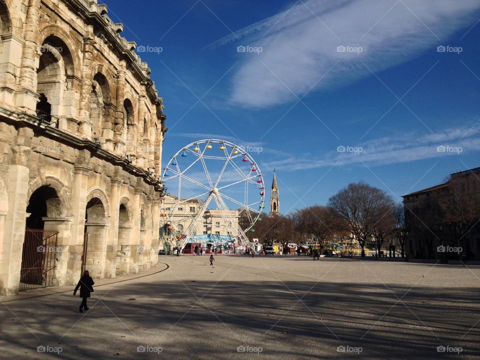 Nimes Arena with Eglise Sainte Perpétue à NIMES in the distance. 

Nimes arena is one of the best preserved Roman amphitheater you will see anywhere. It was remodeled in the mid 19 century and today is served as a bullring and other performance venue. 

Located south of the much more famous Avignon, Nimes is a quite commerce town with rich Roman history without all that tourists. It's definitely worth a half day trip. #nimes #amphitheater #SaintePerpetue 