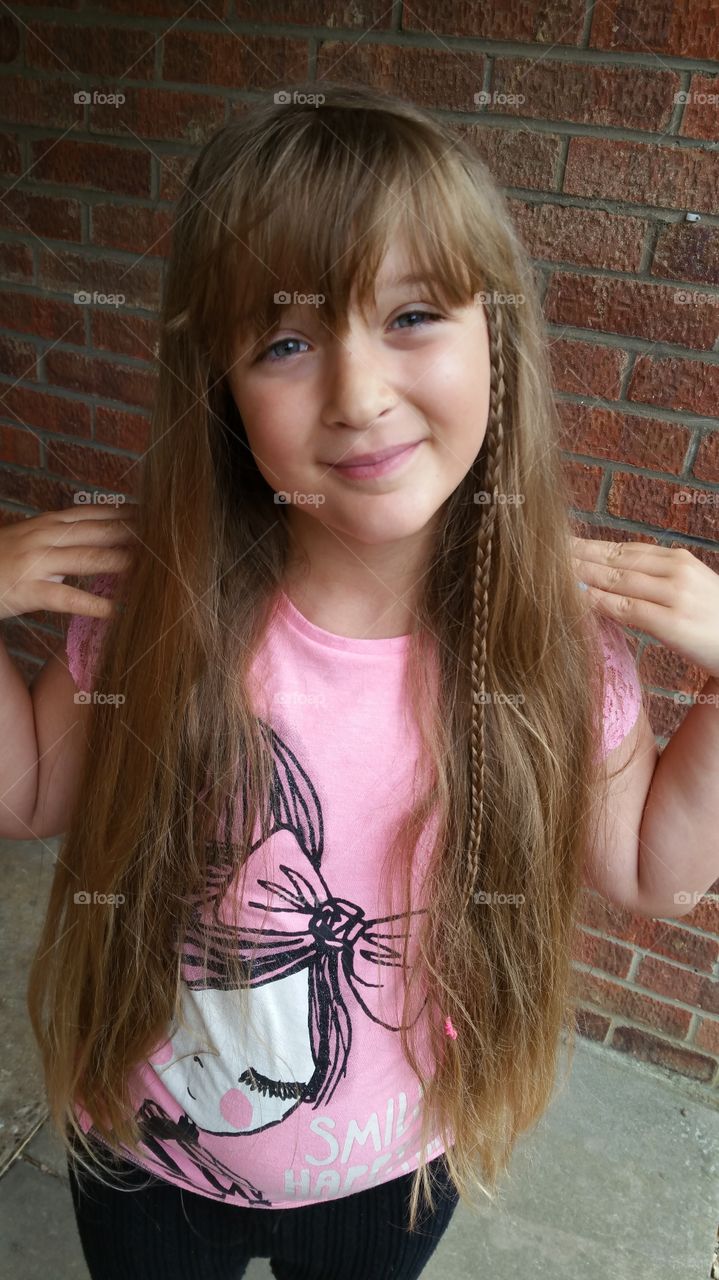 preteen Caucasian girl with long brown hair and blue eyes.
