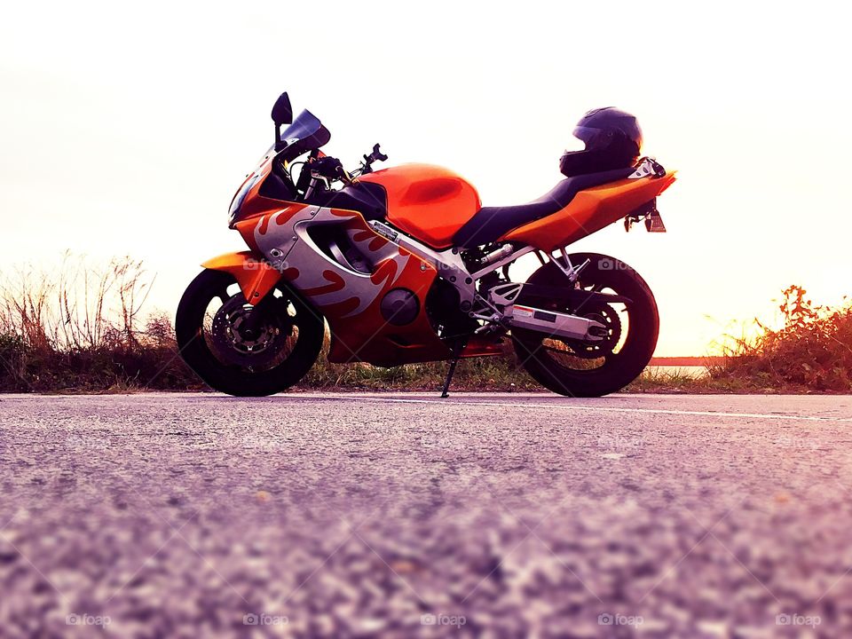 2004 Honda CBR side view helmet on back sunset and sky in background