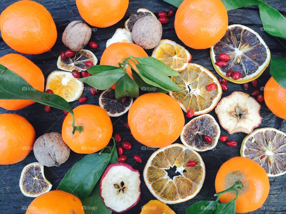 Tangerines with leaves and orange slices on wooden table