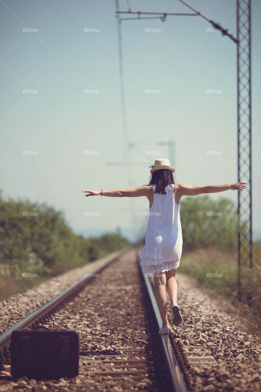 Woman walking on a rail tracks 