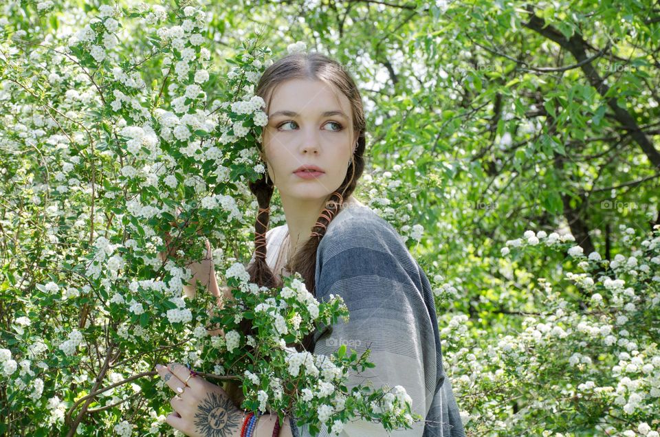 Portrait of Young Girl on Background of Flowers