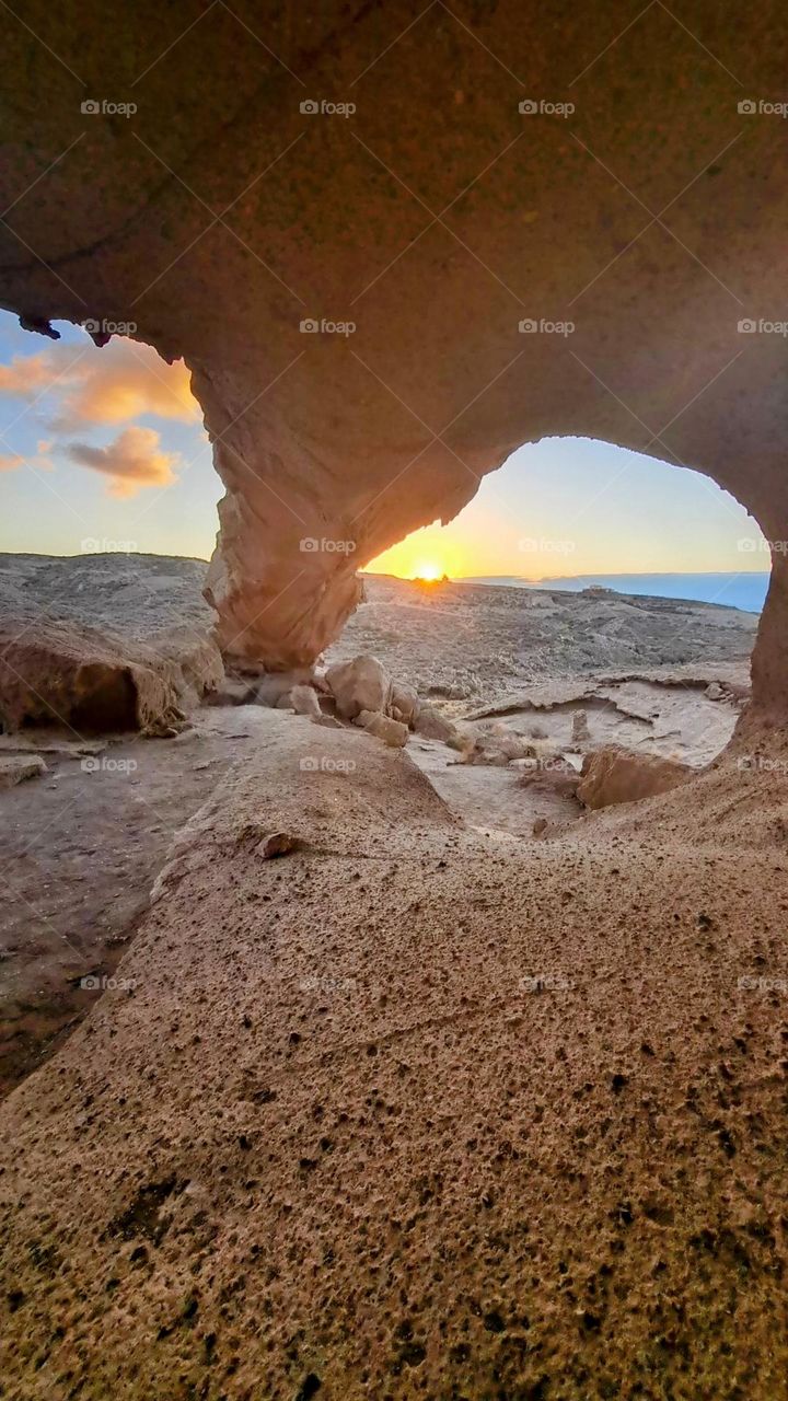 Sunrise trough the natural stone arch , Tenerife , Spain