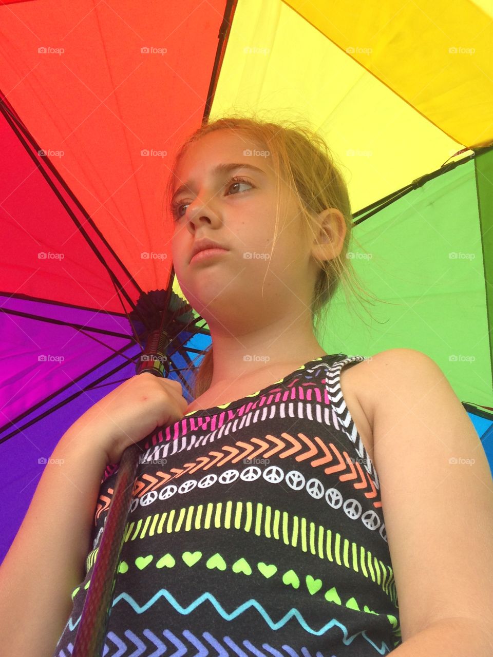 Colorful personality. Girl standing under rainbow umbrella