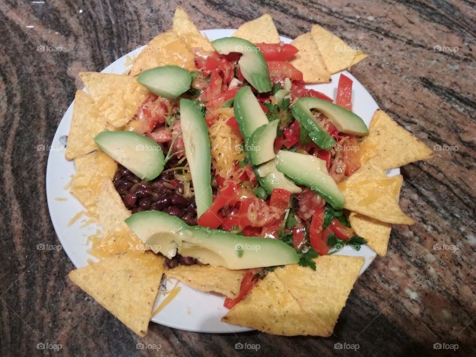 a healthy and colourful nachos with salsa, beans and avocado