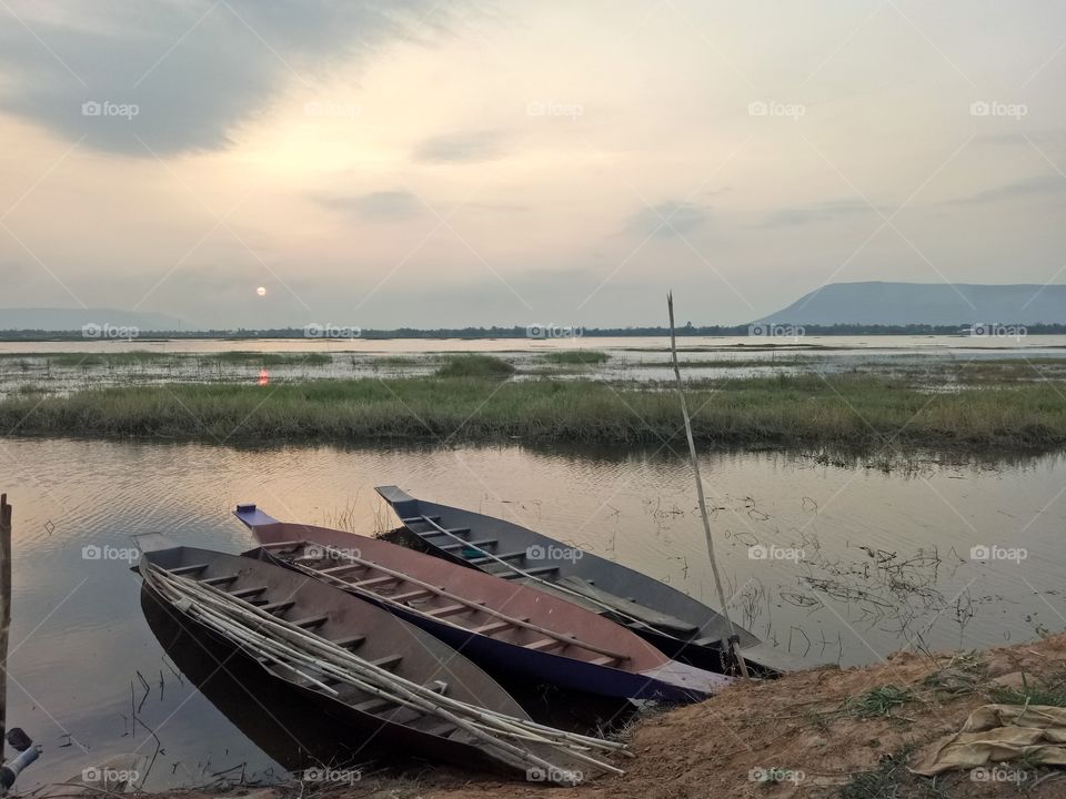 Small fishing boat on the lake during the evening time.