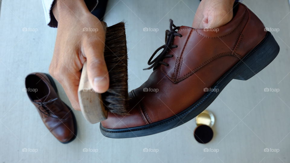 Close-up of person's hand polishing shoes