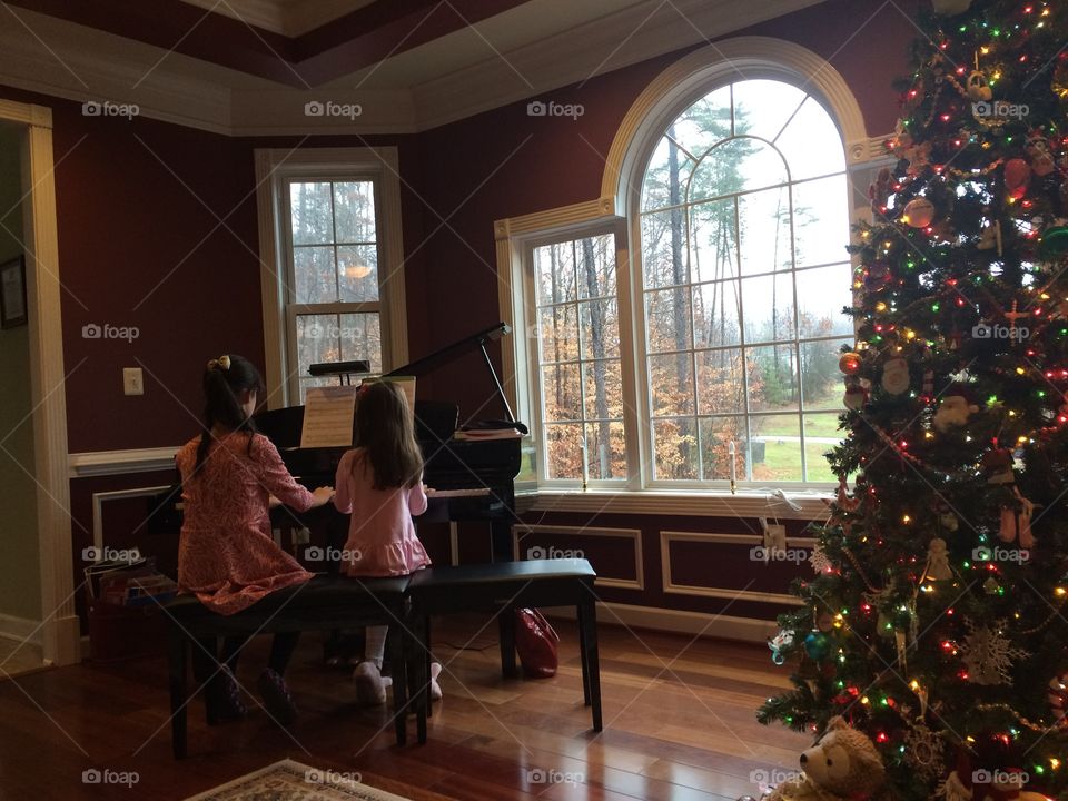 Sisters by the Christmas Tree Celebrating the Holiday by playing Jingle Bells