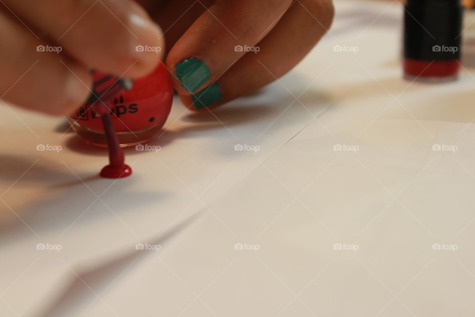 Handy woman putting nail polish drop 