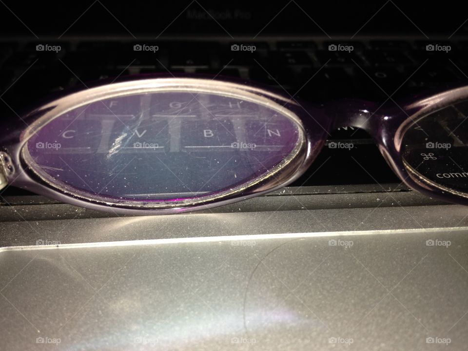 Glasses on a keyboard. Somewhat dirty lens. Writer's block, anyone?