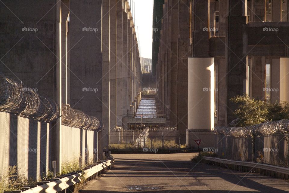 Barb wired fence and concrete pillars make up this highway city down below.