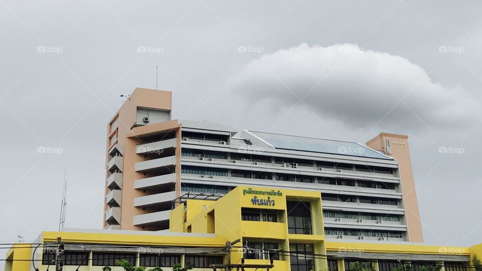 The clouds dot the ordinary buildings that are beautiful.