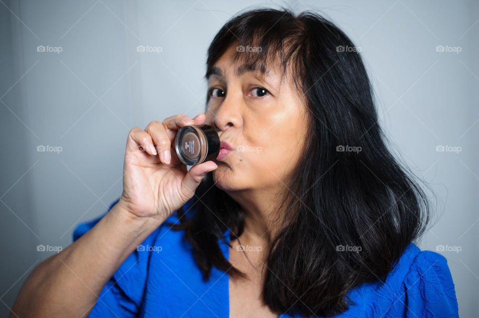 Woman kissing her makeup product 