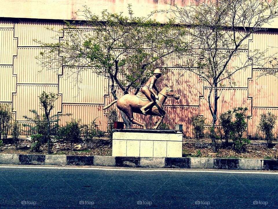 Indian youngster riding on a horse is a statue of a stone