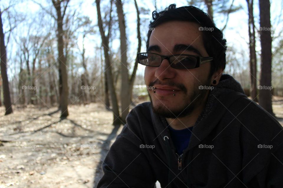 guy shades glasses and lip piercings in woods 