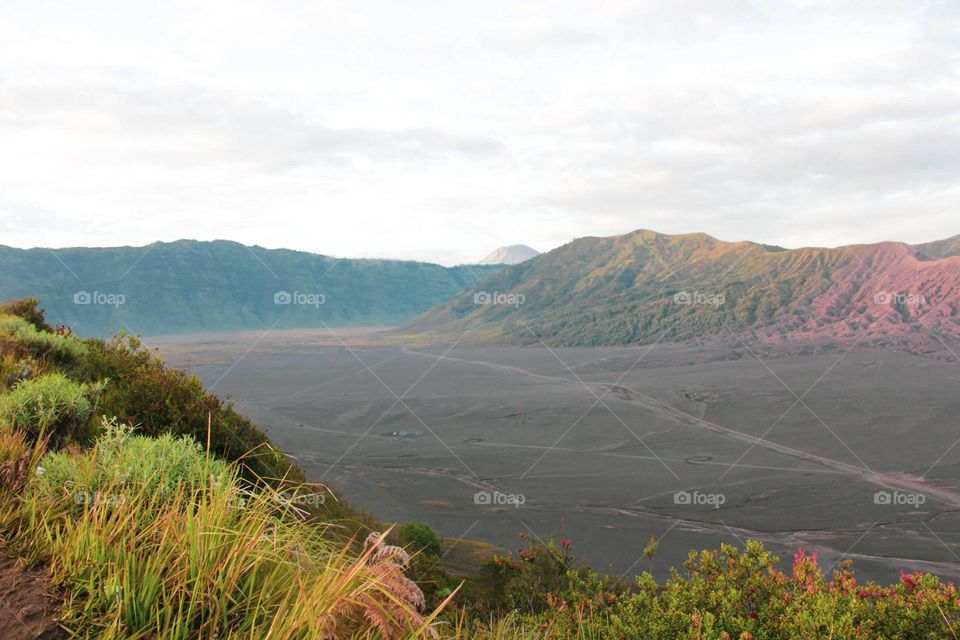 Landscape view of the desert area in the Bromo mountain area in the morning. Favorite tourist attraction with a wide and beautiful sea of ​​sand. Against a backdrop of mountains and clear skies.