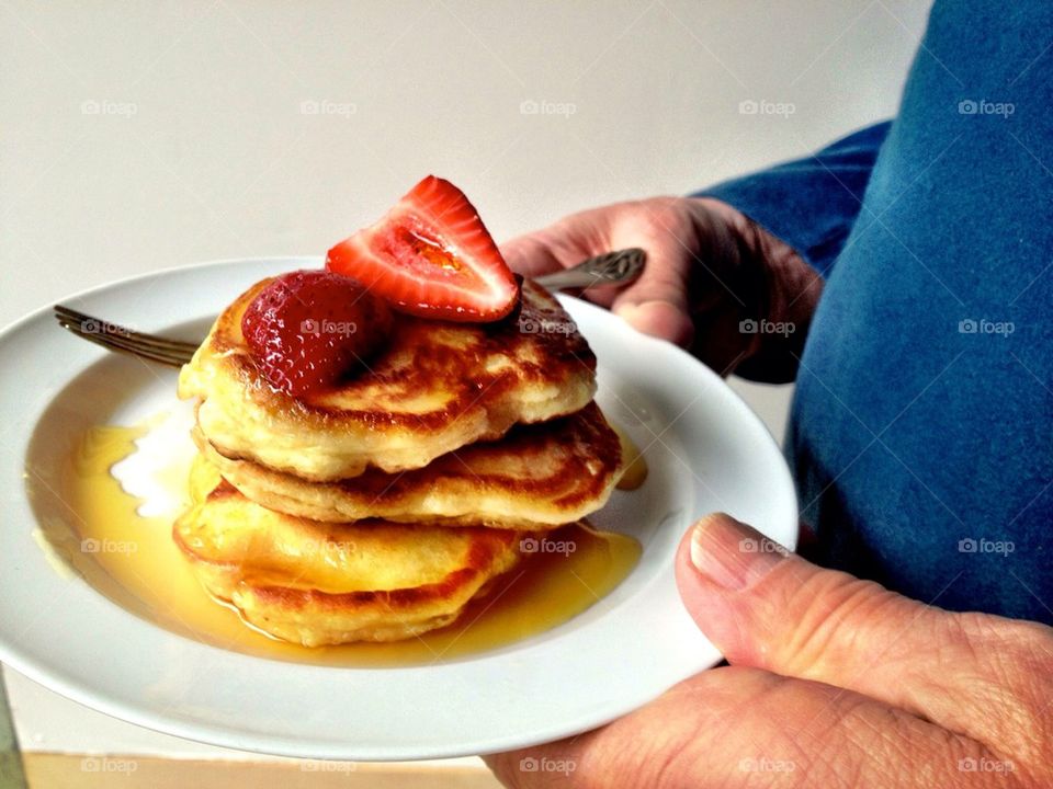 Man holding plate of pancakes