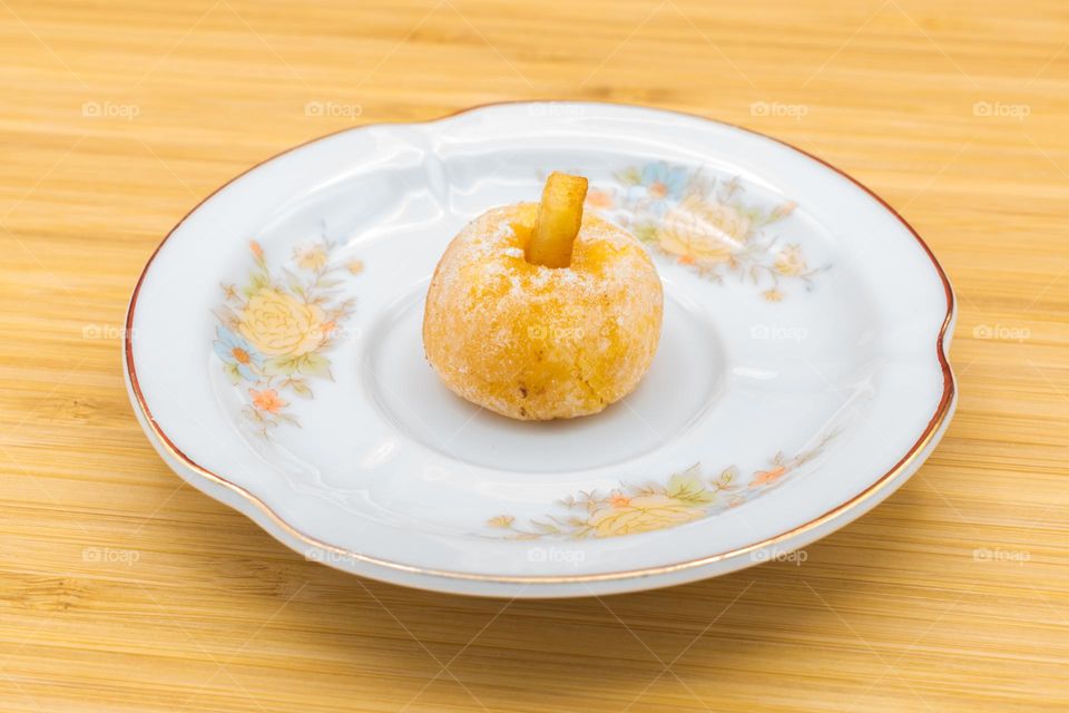 Plate with a panellets on a wooden surface. Panellets are traditional sweets for All Saints' Day in Catalonia, the Balearic Islands, Levante and Aragon.