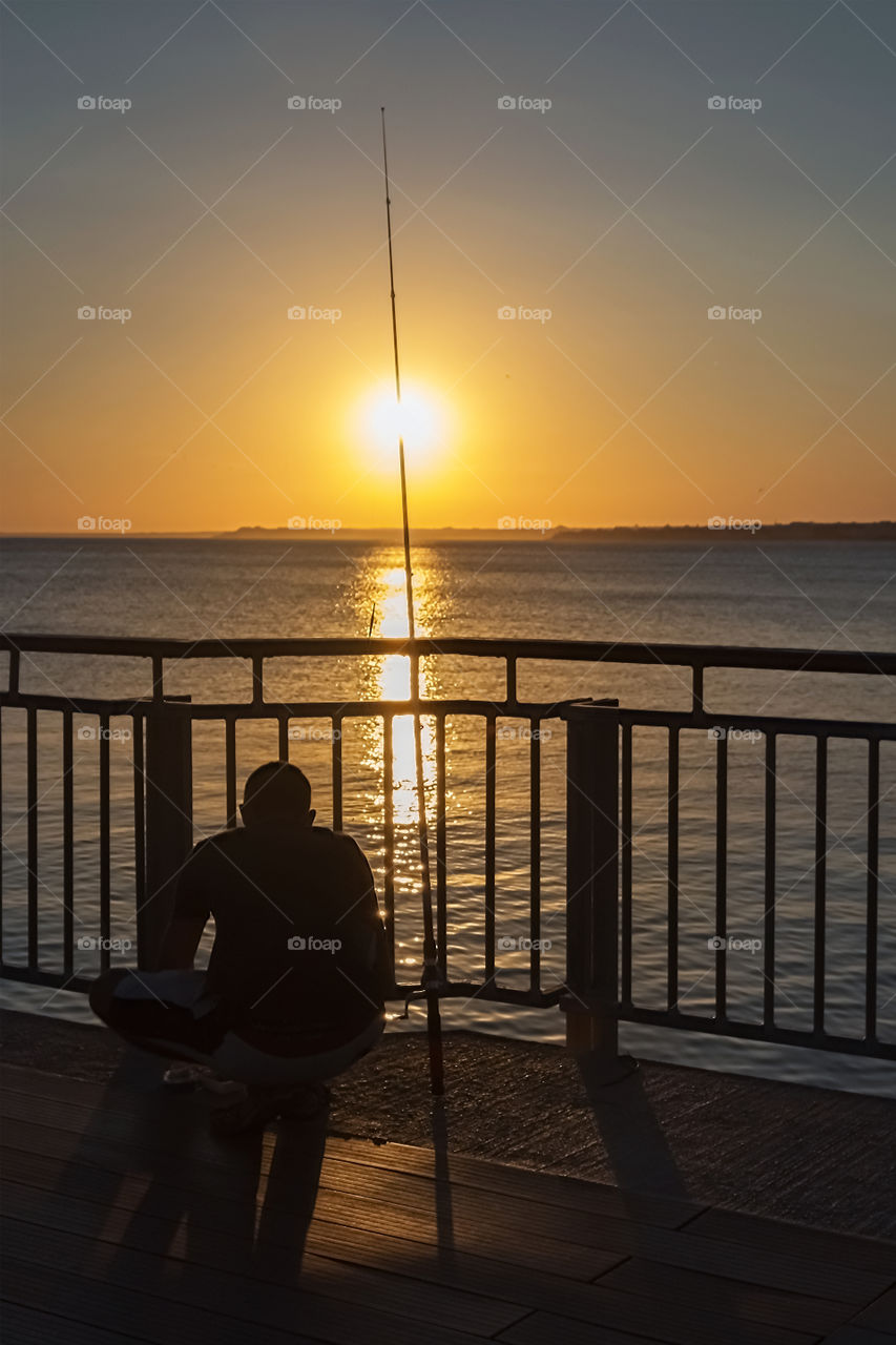 Silhouette of fisherman against beautiful sunset over the Black Sea at Primorsko, Bulgaria