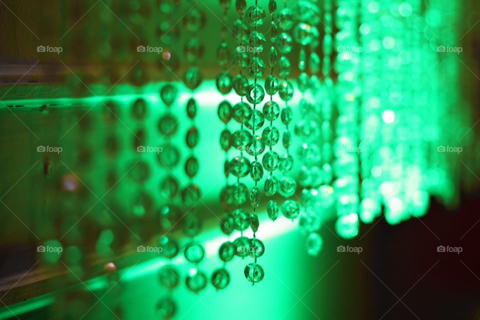 A string of hanging jewels light by a green light