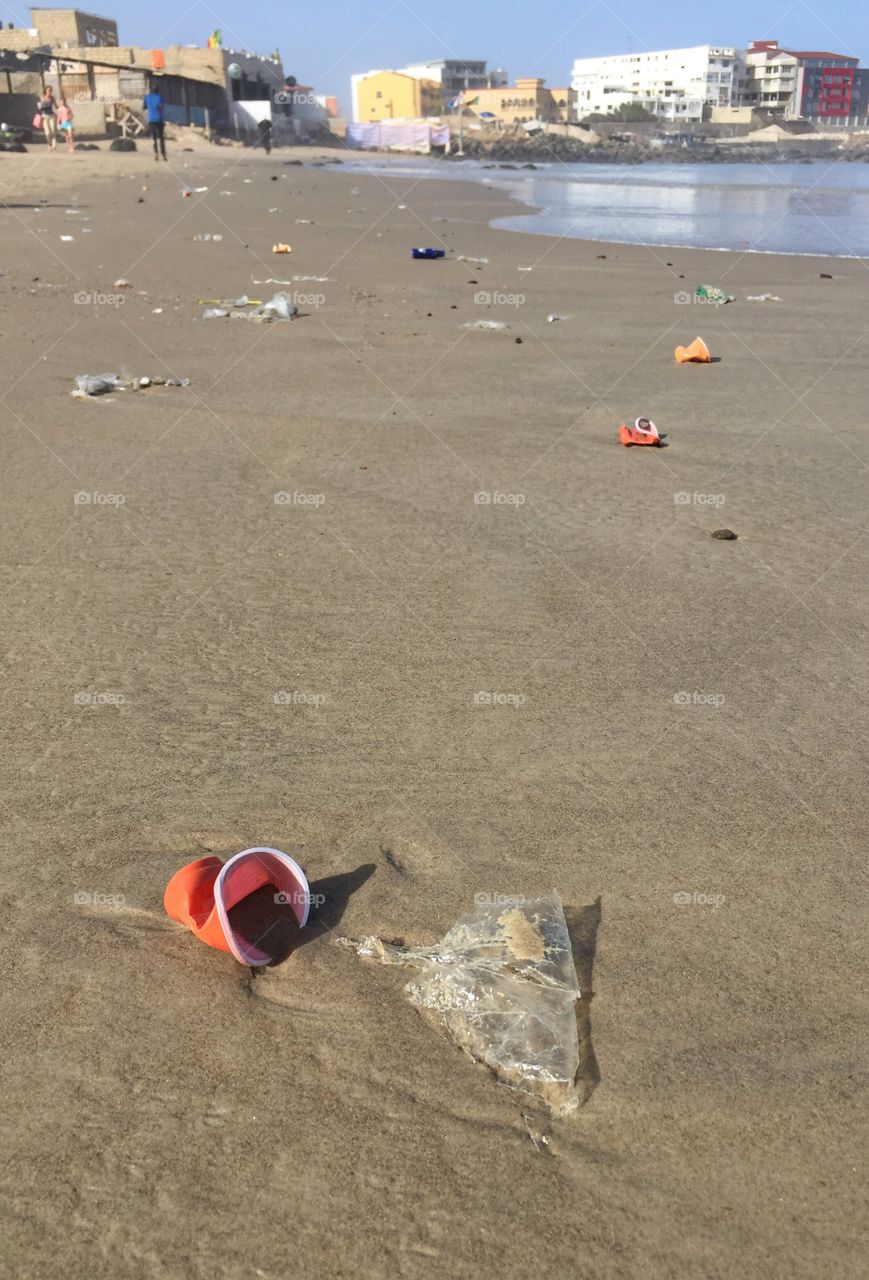 Polluted beach . Plastic cups and other rubbish on a beach