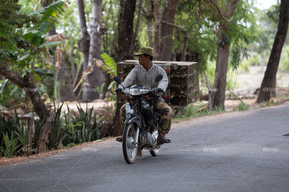 Man ride a motorcycle in countryside of Siem Reap Cambodia