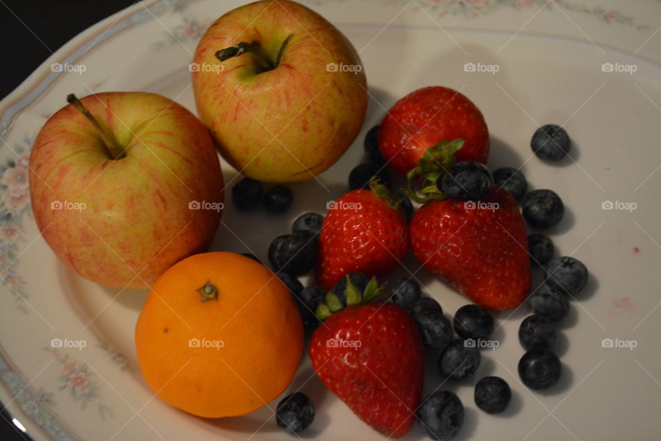 Plater of fruit of apple,orange, blueberries and strawberries 